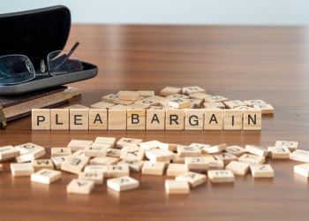 Wooden Scrabble tiles arranged on a table spell out the phrase 